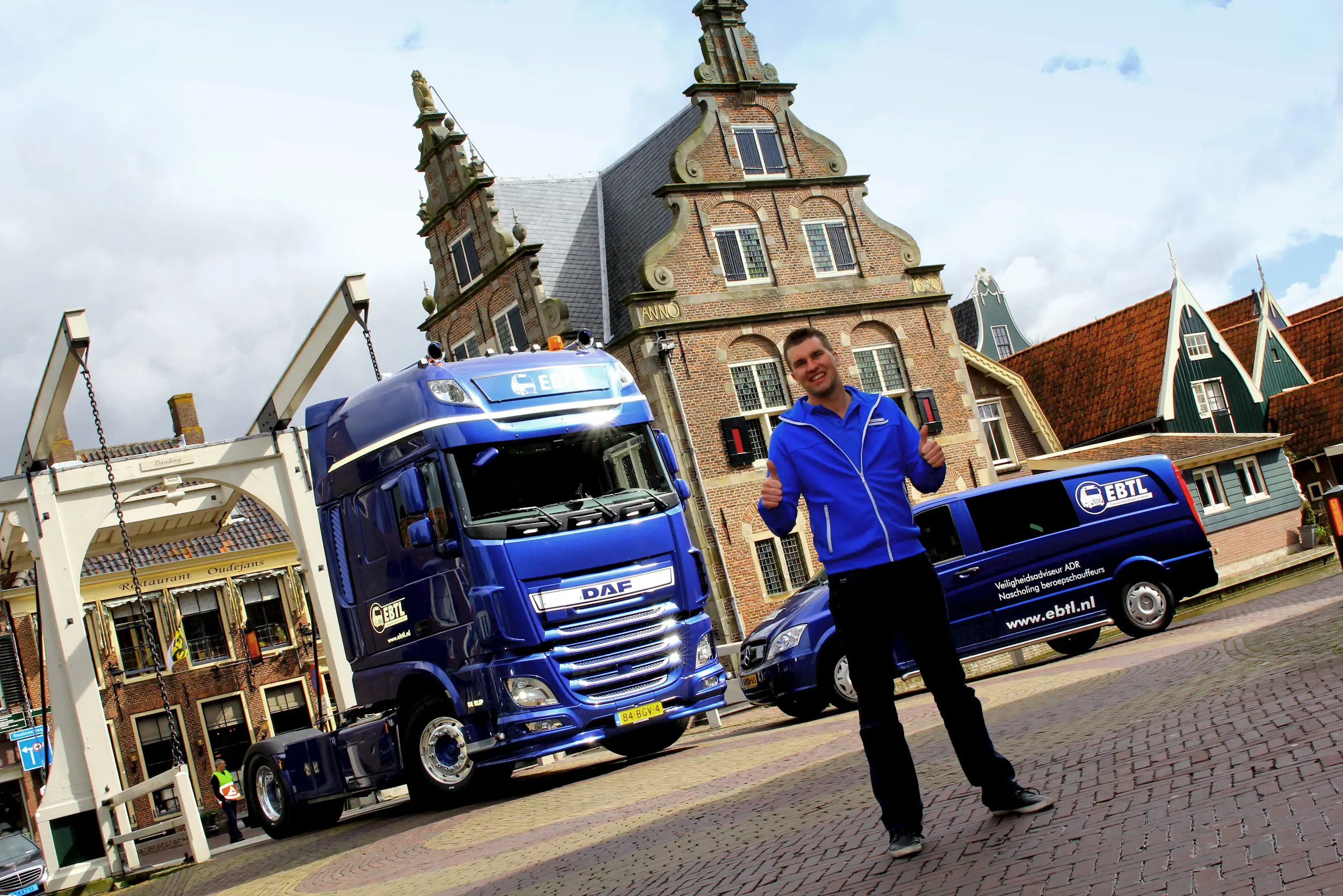 Erik Boots van EBTL staat bij vrachtwagen en bedrijfsbus van zijn transportadviesbedrijf op historisch plein in De Rijp