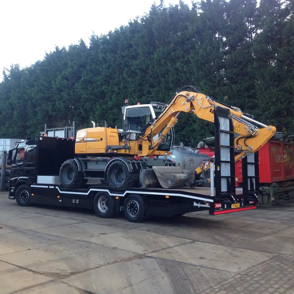 Dieplader vervoert graafmachine op oplegger voor zwaar transport van bouwmaterieel